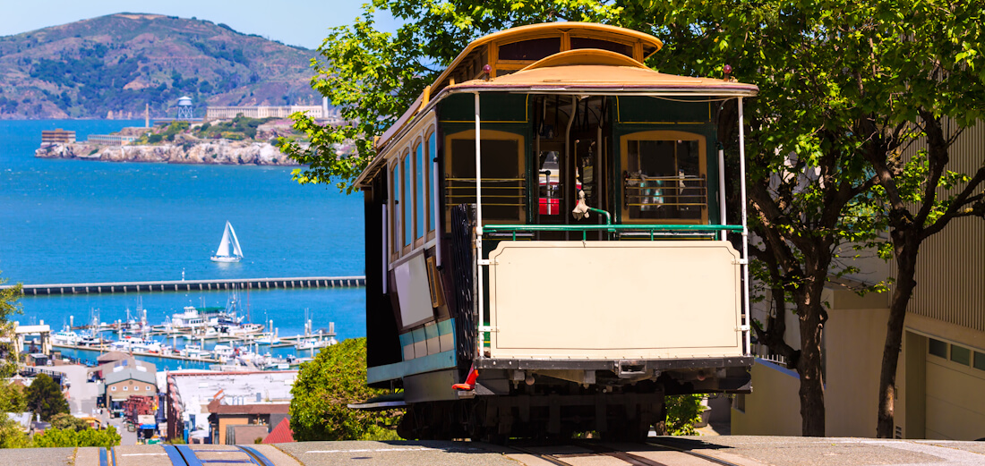 A tram in San Francisco with the Bay and Alcatraz in the background